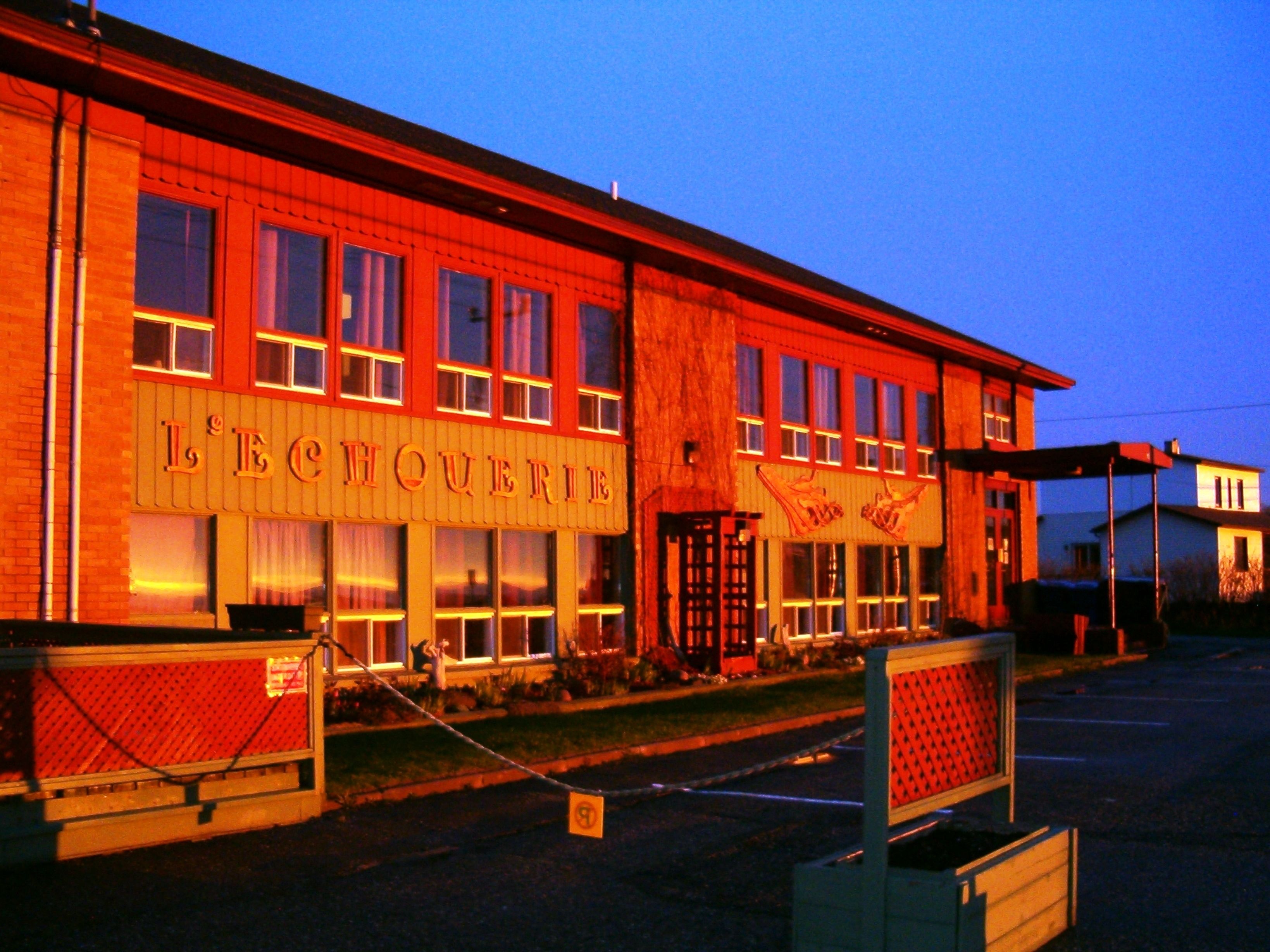A building with a sign reading "L'ECHOUERIE" at twilight.
