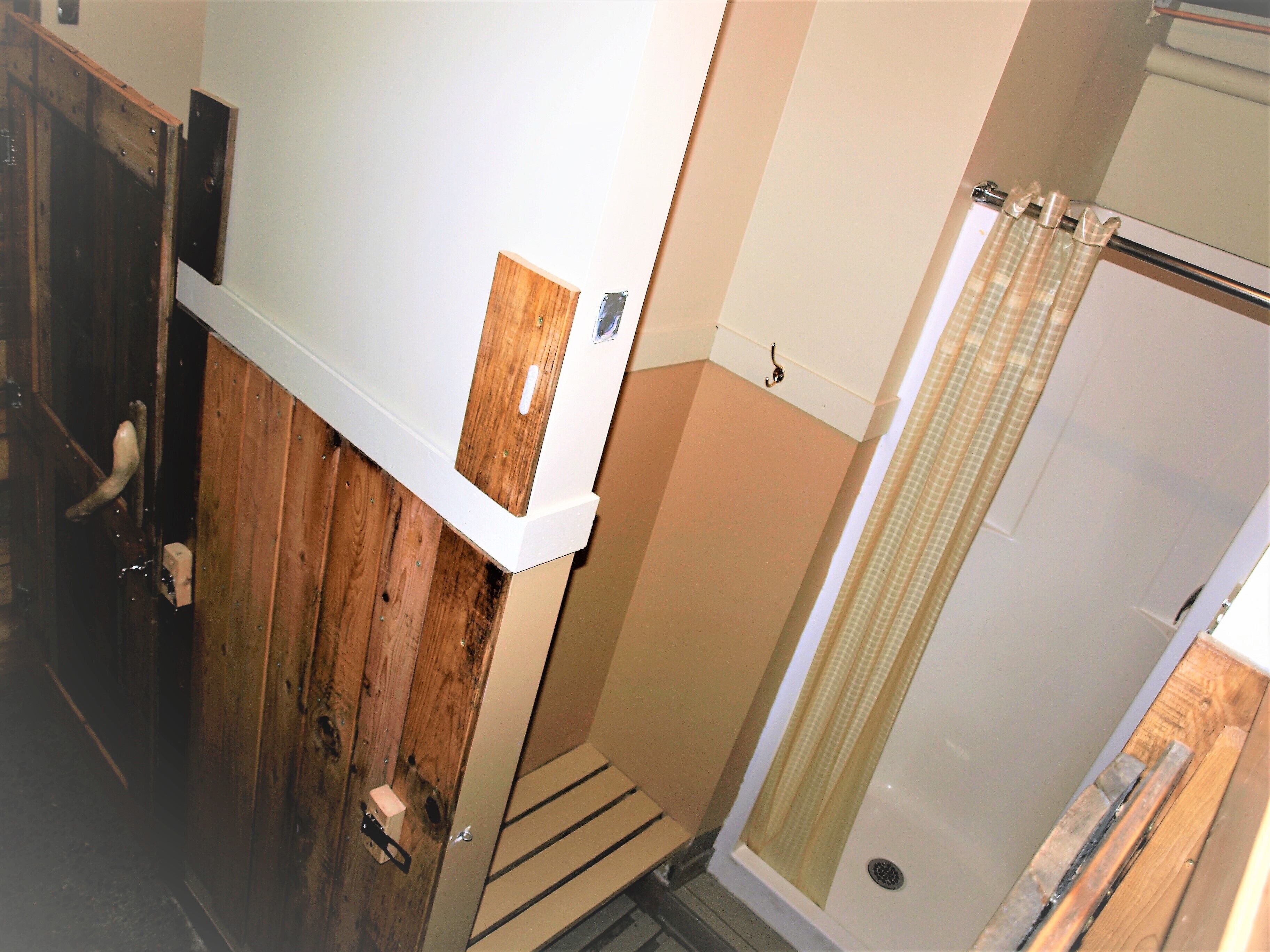 A bathroom with a wooden vanity, a shower with a curtain, and a white bathtub.