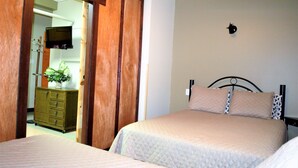 A bedroom with two beds, a wooden wardrobe, and a dresser. - Auberge Internationale La Vieille École (Sainte-Anne-des-Monts)