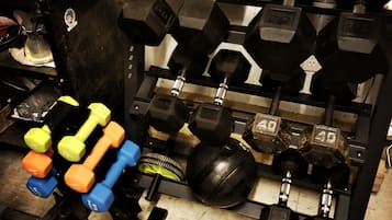 Une salle de sport à domicile équipée de divers poids et appareils d'exercice.