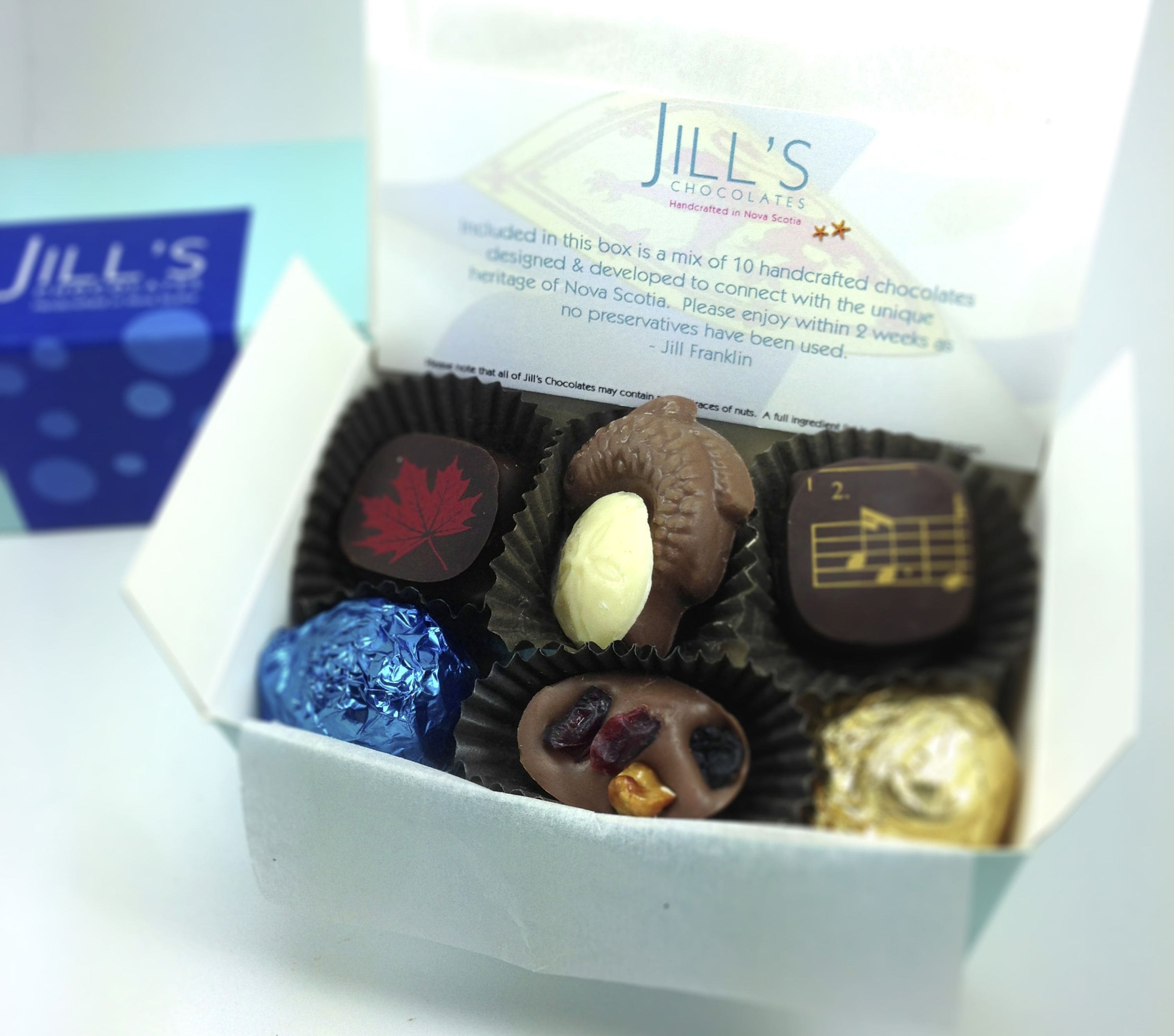 Una caja de bombones variados con una etiqueta que dice "Jill's Chocolates".