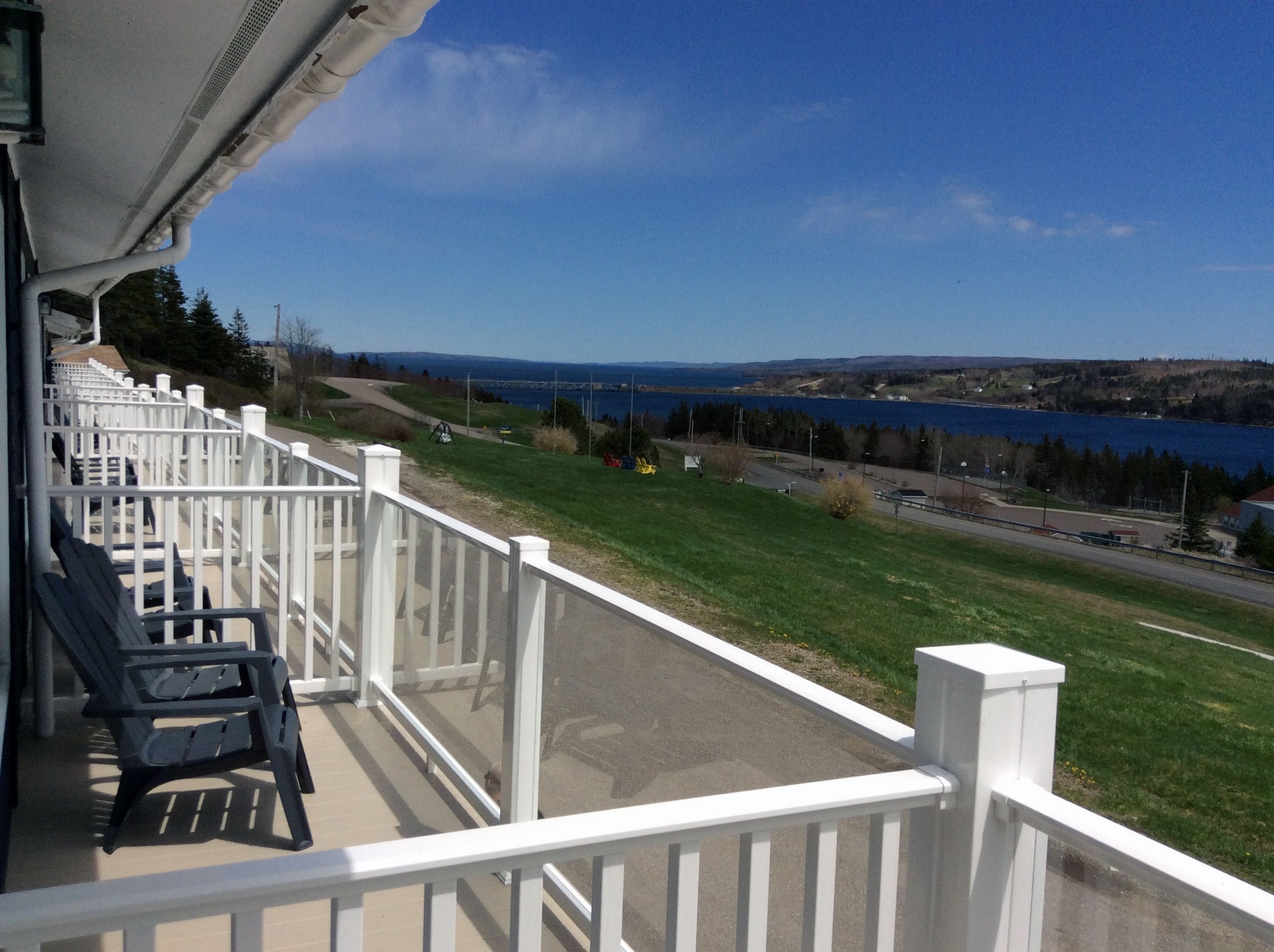 Un balcon donnant sur un lac et une route.
