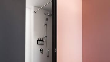 A modern bathroom with a shower, toilet, and storage cabinet.