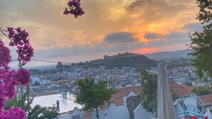 A terrace with a view of a cityscape, a swimming pool, and potted plants. - Villa Dreams (Selçuk)
