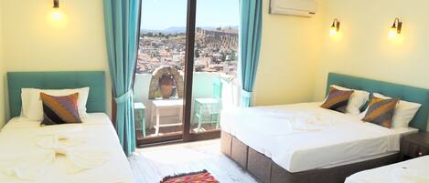 Habitación de hotel con dos camas, vista a la ciudad, balcón con mesa y sillas, y aire acondicionado.