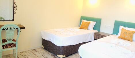 Habitación de hotel con dos camas, una silla y un escritorio.