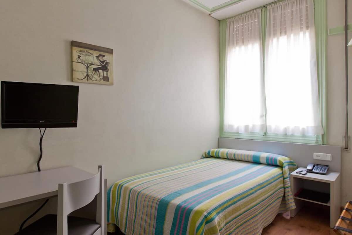 Quarto solteiro | Escrivaninha, cortinas blackout, Wi-Fi de cortesia