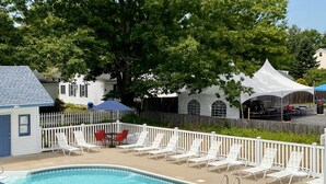 A pool area with lounge chairs and a white fence. - Seacoast Motel (Wells)