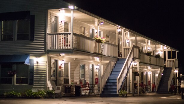 A two-story motel with a balcony on the second floor, a staircase, and outdoor seating. - Seacoast Motel (Wells)