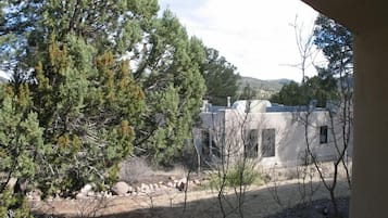 A building with a stone facade, surrounded by trees and a dry landscape.