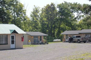 Een motel met twee bungalows, een picknicktafel en een vrachtwagen ervoor geparkeerd.