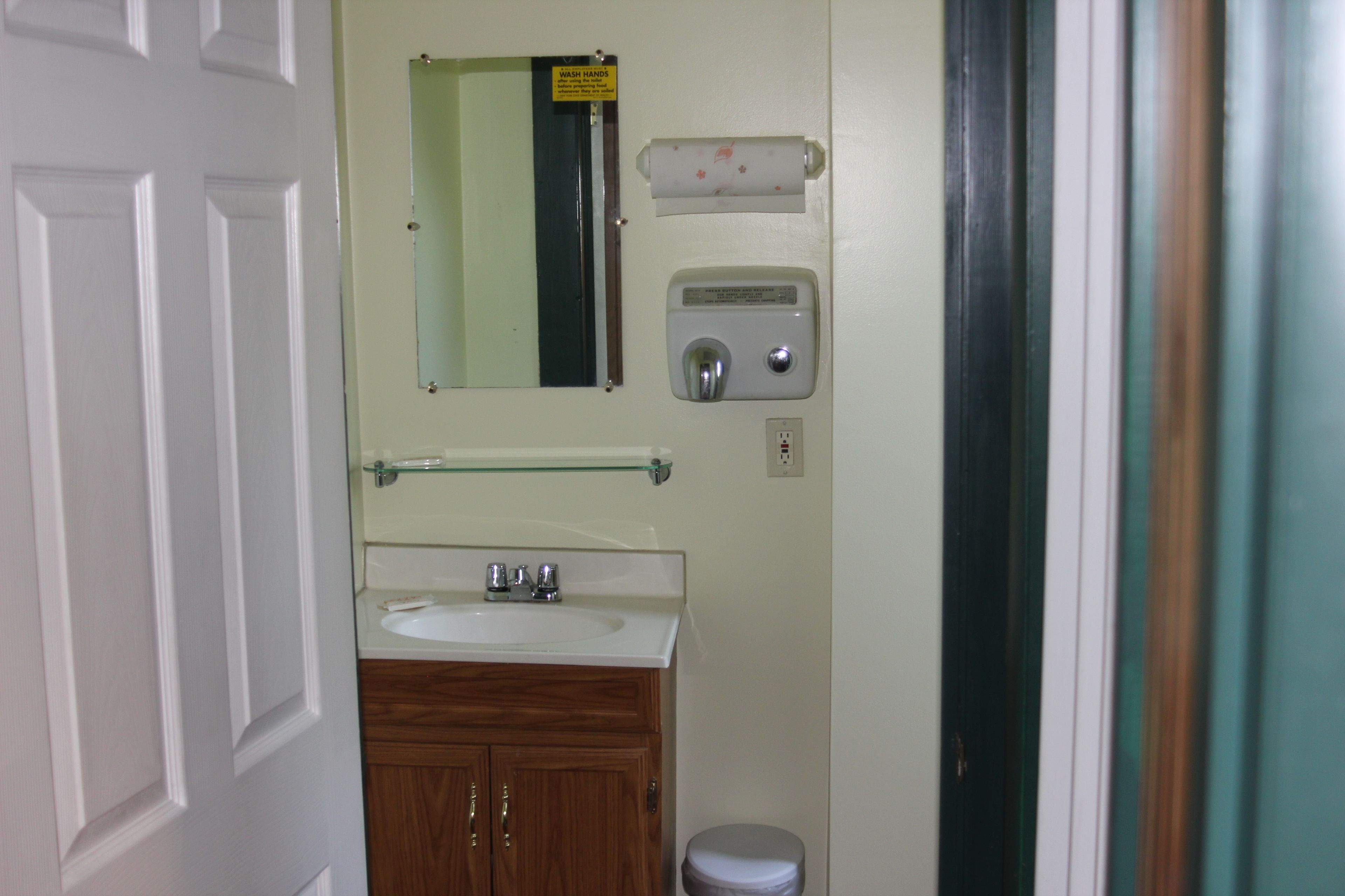 A bathroom with a sink, mirror, and toilet.