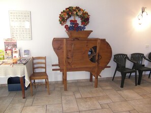Un comedor con un aparador de madera, una mesa con mantel de encaje y sillas.