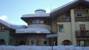 Ein mit Schnee bedecktes Gebäude, auf dem das Schild "via di Carbonara" zu lesen ist.