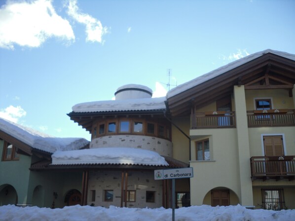 Un edificio cubierto de nieve con un letrero que dice "via di Carbonara".