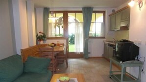 Ein kompakter Wohnbereich mit Sofa, Esstisch und Küchenzeile.