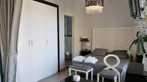 Un dormitorio moderno con una cama grande, una mesita de noche, una silla y un armario.