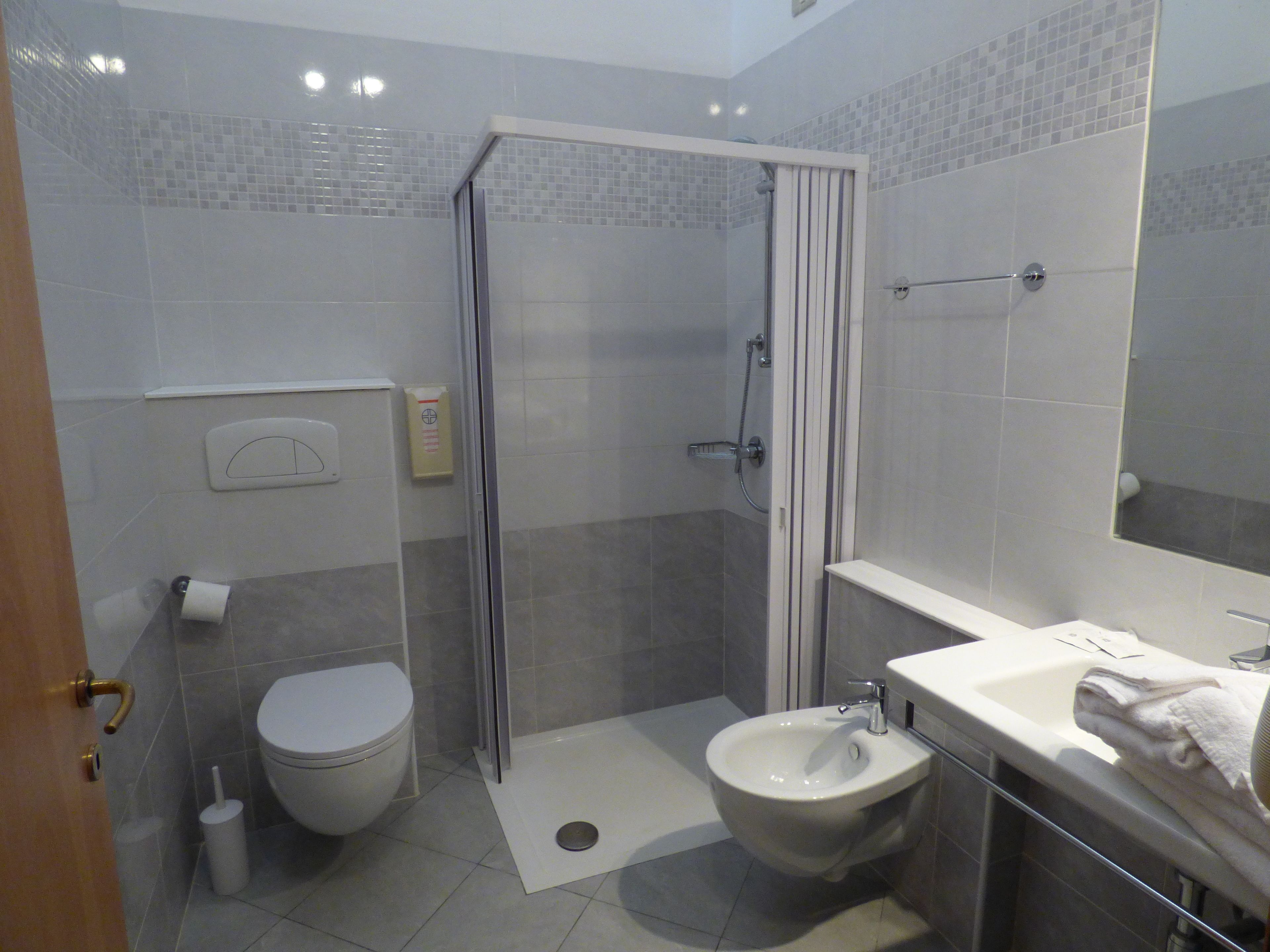 Une salle de bain comprenant des toilettes, un bidet, une douche et un lavabo.