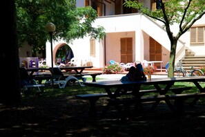 Un patio con mesas de picnic y una bicicleta.