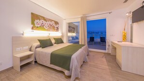 Une chambre d’hôtel avec un lit, une table de chevet, un bureau et un tableau au mur.