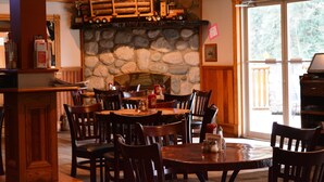 Ein Restaurant mit Steinwänden, Holzmöbeln und einem Kamin.