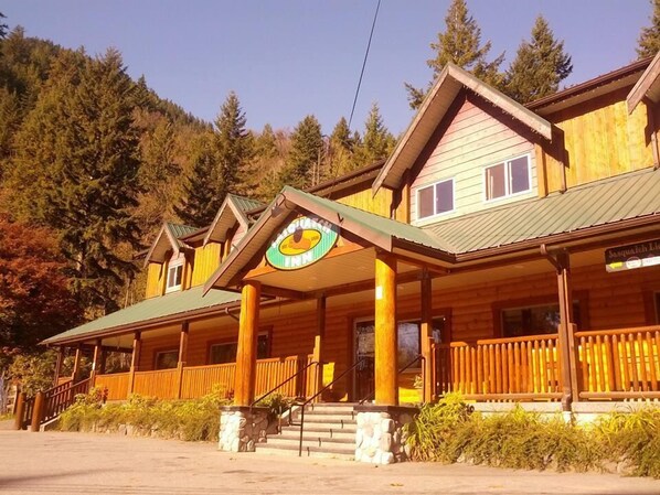 A wooden lodge with a porch and a sign that reads "Jasquatch Inn".