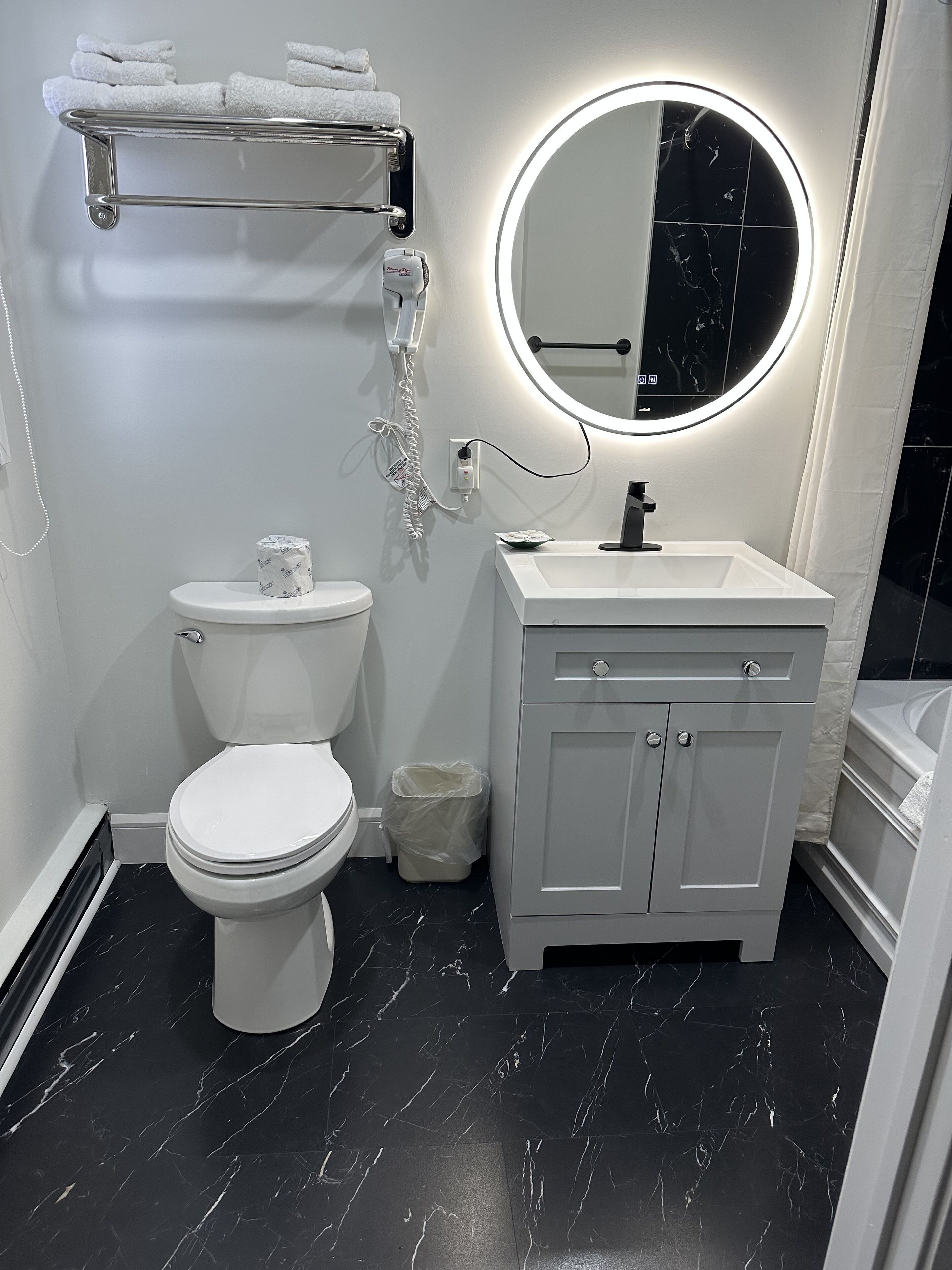 A modern bathroom with a toilet, sink, and mirror.