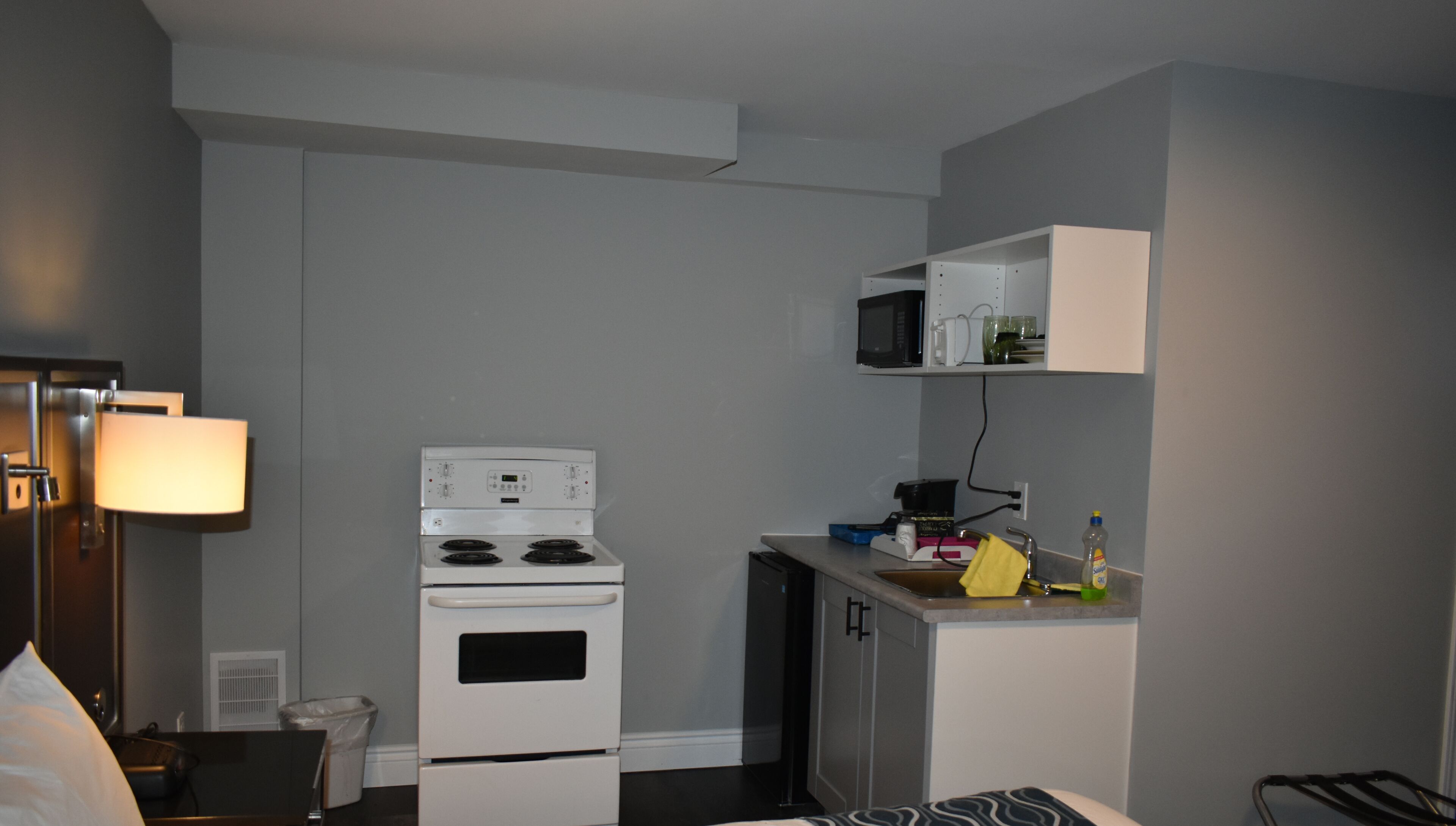 A compact kitchen with a stove, microwave, and small countertop.