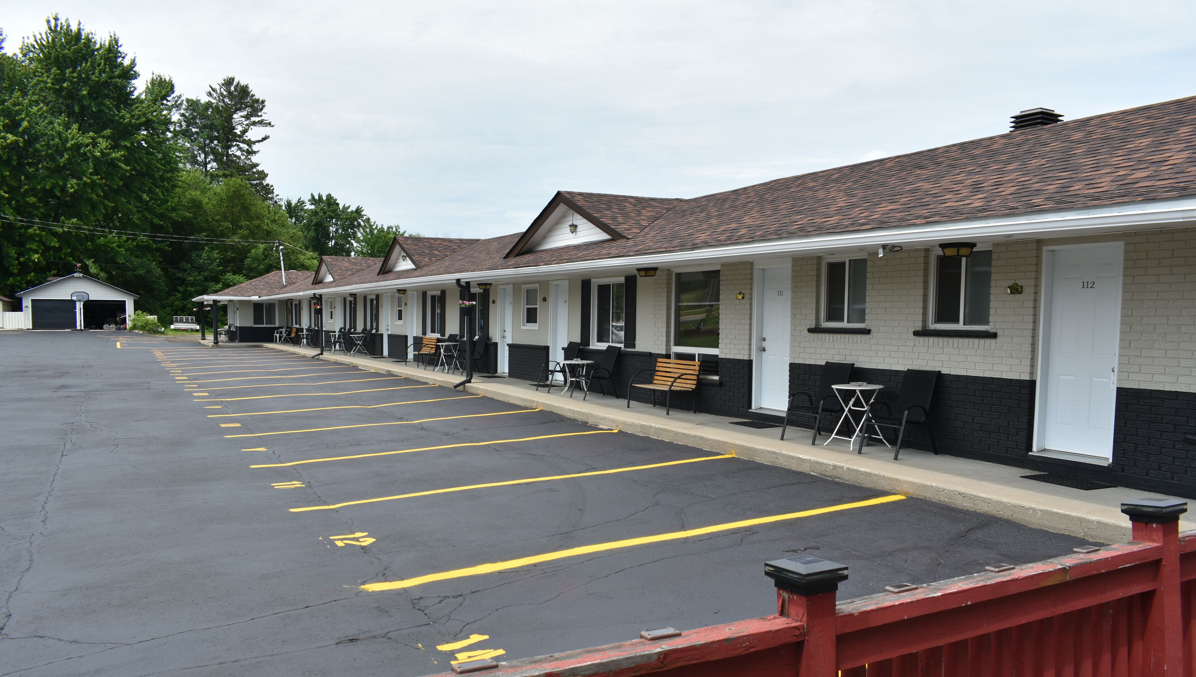 A row of motel rooms with individual parking spaces.