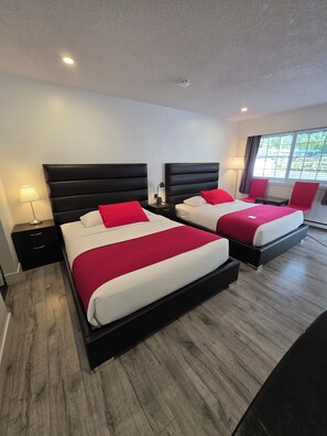 A hotel room with two beds, a nightstand, a lamp, and a window with a view. - Alpine Motel (Hope)