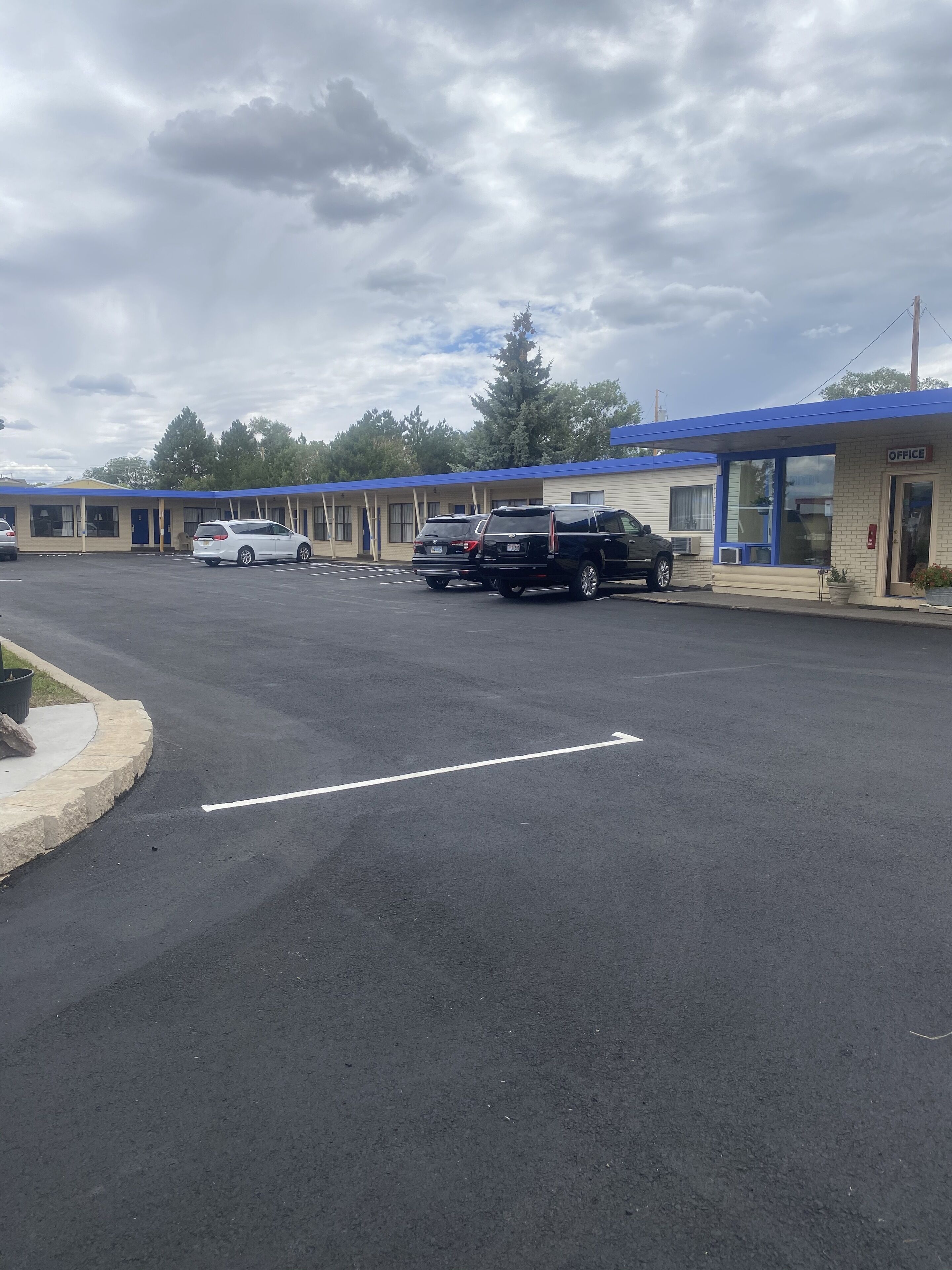 A motel with multiple rooms, a parking lot, and a small office building.