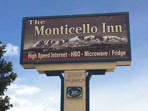 A sign for The Monticello Inn advertising amenities like high-speed internet, HBO, microwave, and fridge.