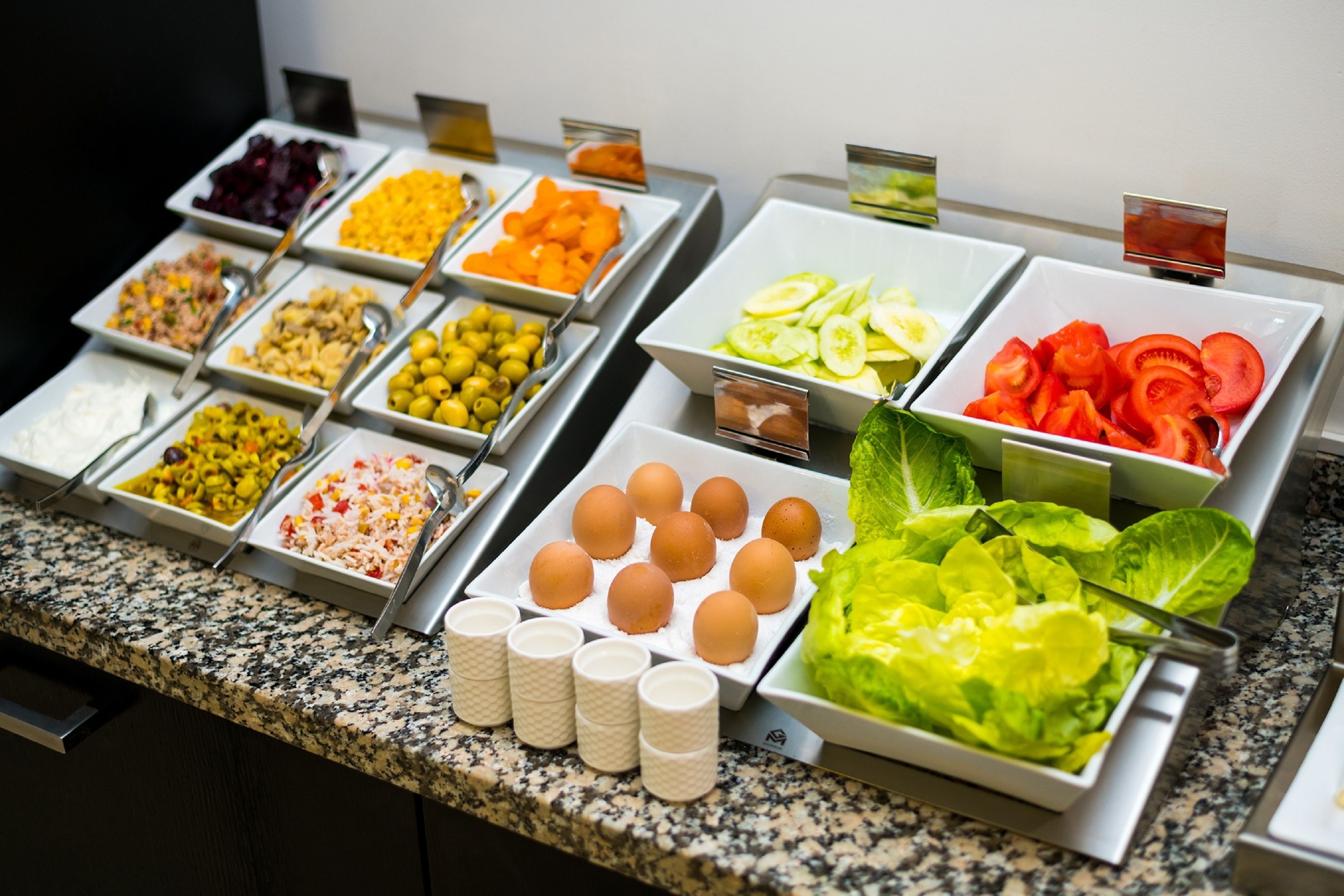 Ein reichhaltiges Buffet mit verschiedenen Speisen, darunter Eier, Gemüse und Früchte.