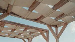 A wooden pergola with a view of the ocean. - Kenting South Border DeSign Hotel (Hengchun)