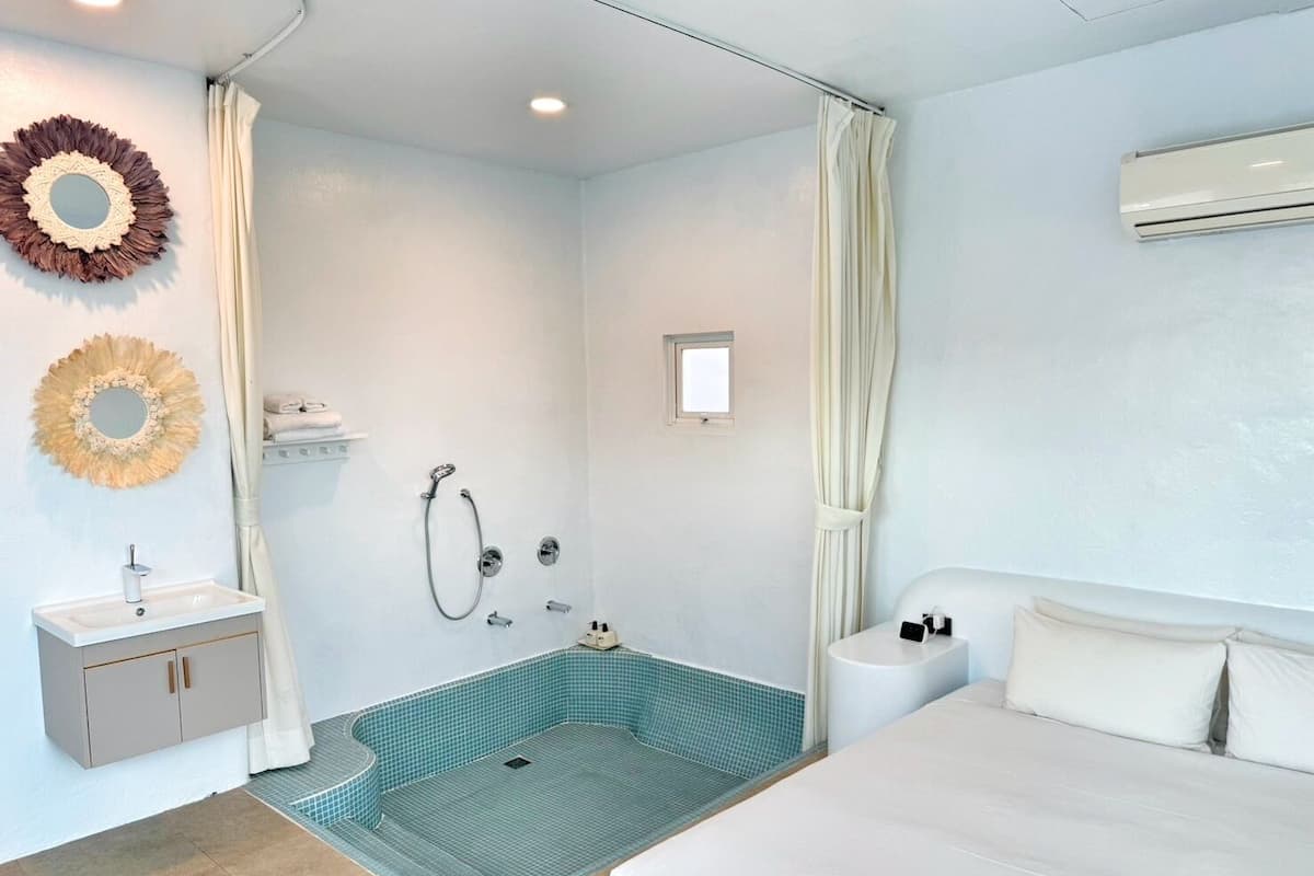 A modern bathroom with a shower, sink, and toilet.