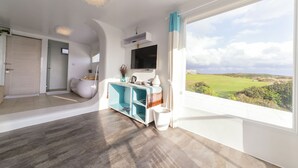 A modern room with a large window, a flat-screen TV, and a teal console table. - Kenting South Border DeSign Hotel (Hengchun)