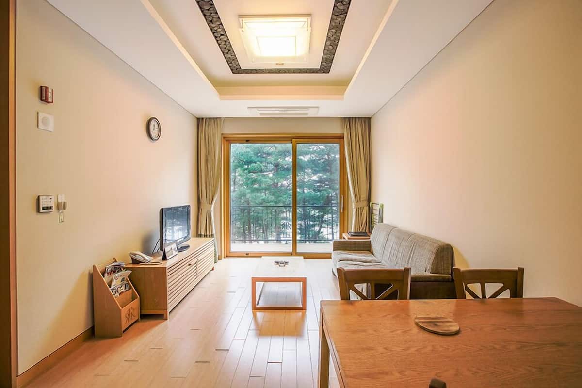 A living room with a sofa, a coffee table, a TV, and a wooden cabinet.