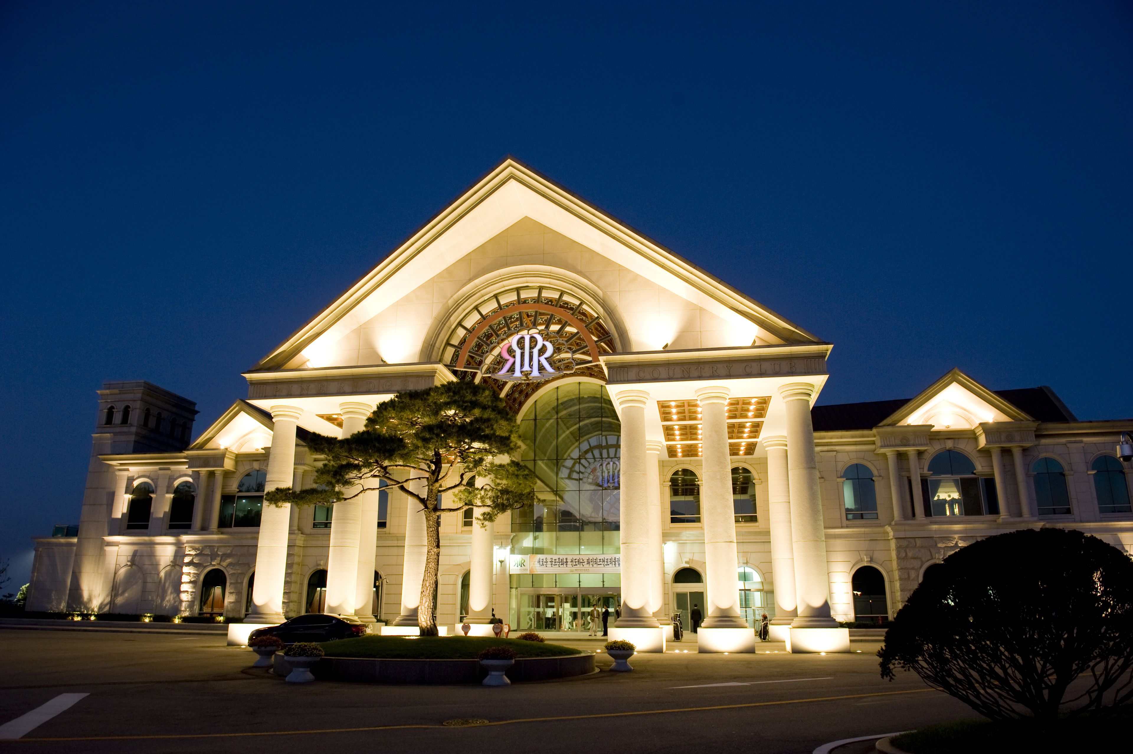 A grand building with a large arched entrance and columns, likely a hotel or public building.