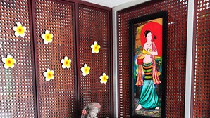 A decorative indoor garden with a statue, potted plants, and a framed picture on the wall. - Choktawee Smile (Chiang Mai)