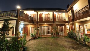 A two-story building with a courtyard, balconies, and potted plants. - ThongRan's house (Chiang Mai)