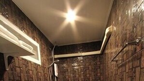 A bathroom with a modern design, featuring a shower, toilet, and a sink with a dark countertop. - ThongRan's house (Chiang Mai)