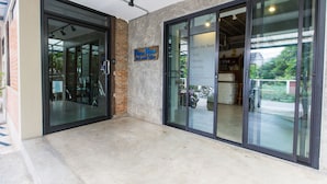 A modern building with glass doors and a sign indicating a room for rent. - Plern Plern Bed and Bike (Chiang Mai)