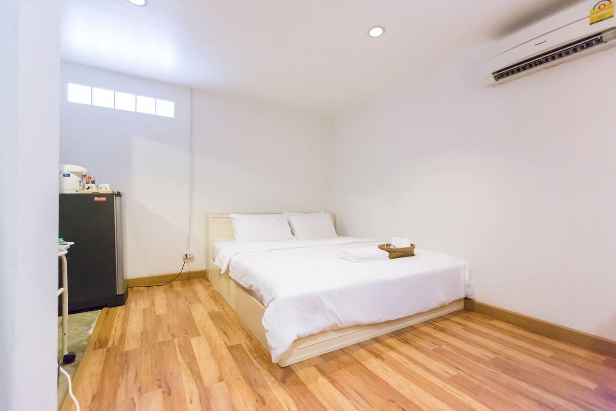 Une chambre à coucher avec un lit, un bureau et un climatiseur.