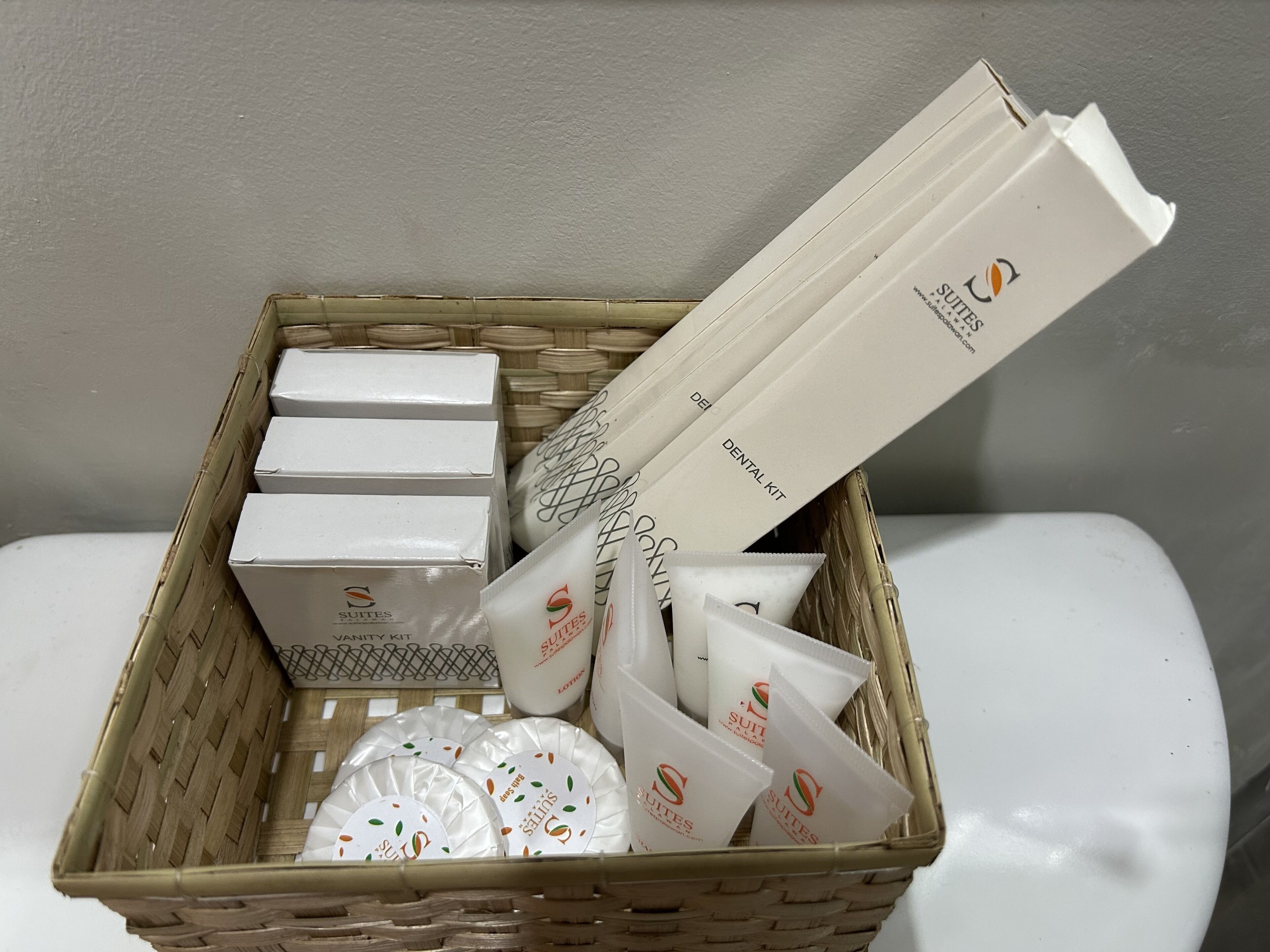 A wicker basket containing toiletries and a dental kit.