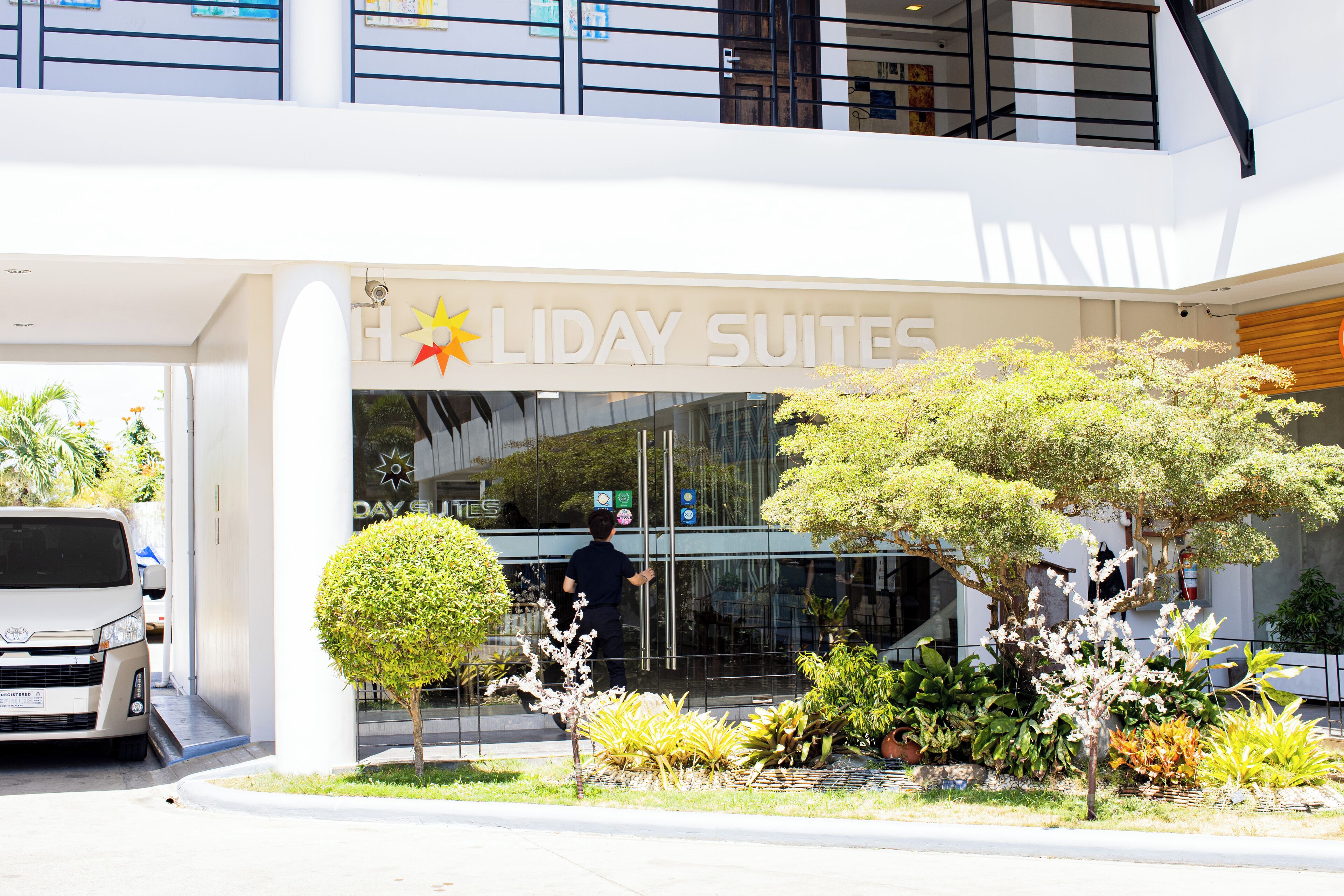 A modern hotel entrance with a sign reading "Holiday Suites".