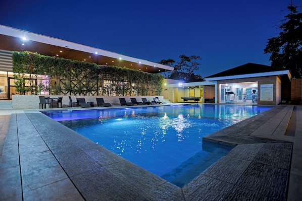 Una piscina al aire libre, tumbonas