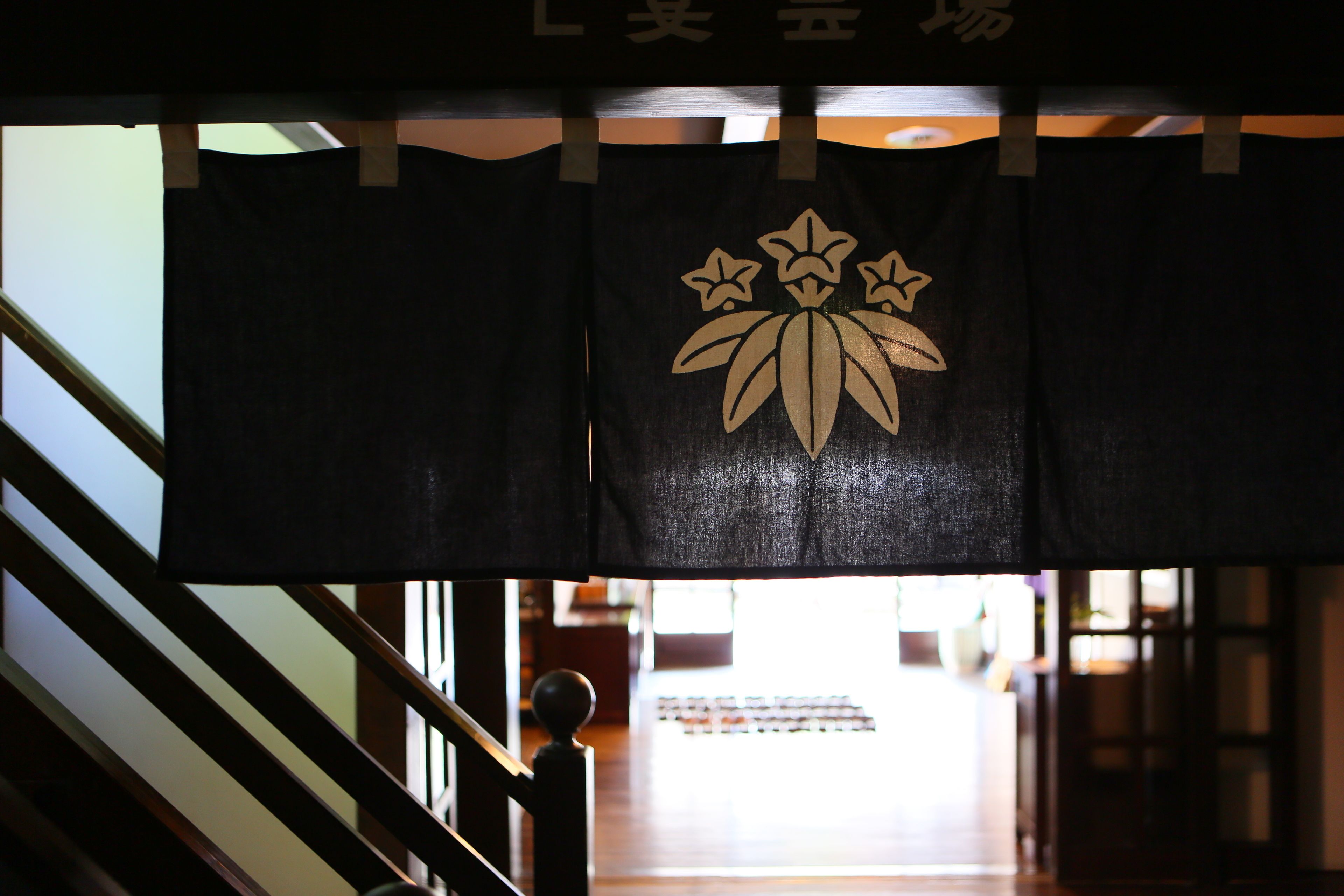 A staircase with a black fabric banner featuring a gold floral design.