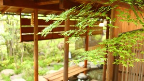 Perinteinen japanilainen puutarha, jossa on puisia rakennelmia, kivisilta ja lampi.