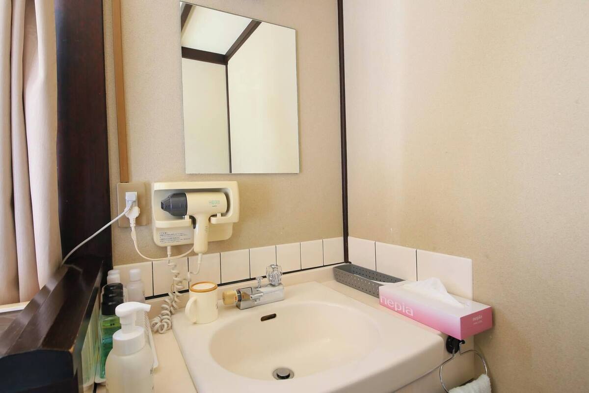 Een badkamer met een wastafel, spiegel en toiletartikelen.
