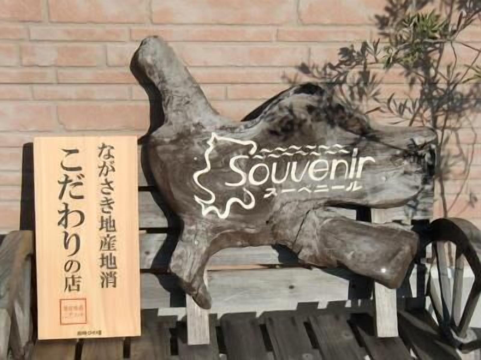 Una escultura de madera con la palabra 'Souvenir' y texto en japonés.